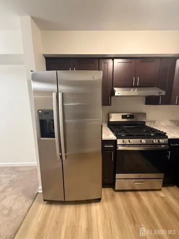 a metallic refrigerator freezer sitting in a kitchen