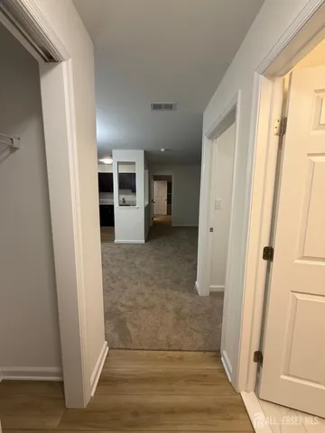 a view of a hallway with wooden floor and entryway