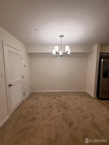 an empty room with chandelier fan and windows