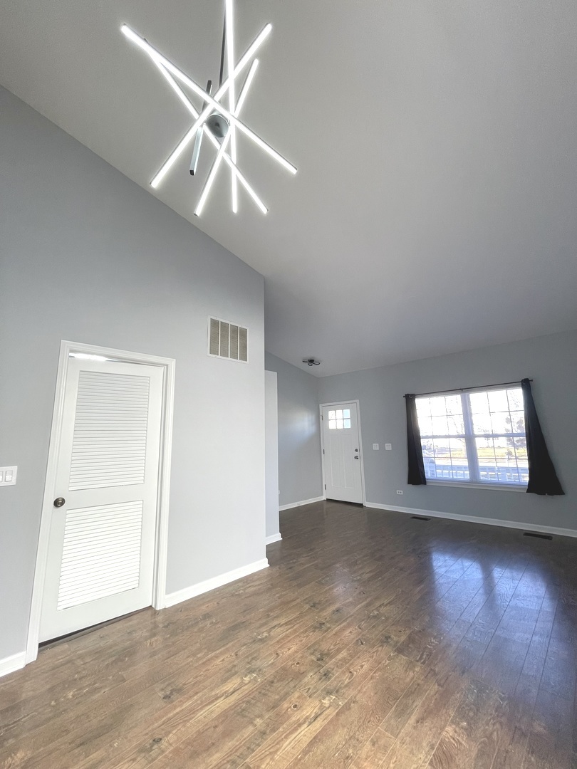 16623 Natoma Drive, Unit 16623 Lockport, IL 60441 - Photo 3 of 27 a view of an empty room with window and wooden floor