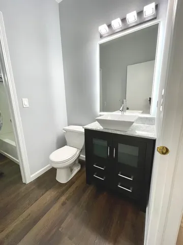 a bathroom with a granite countertop toilet sink and mirror