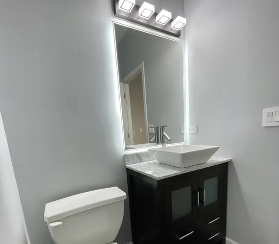 a bathroom with a sink a toilet and mirror