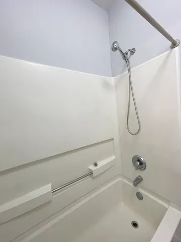 a bathroom with a bath tub with a shower