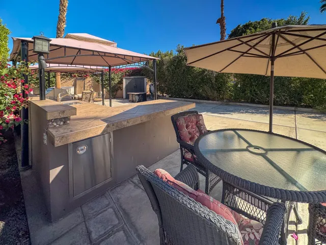 a patio with swimming pool table and chairs