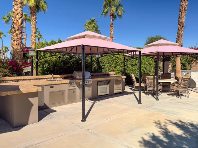 a view of a patio with a table and chairs under an umbrella