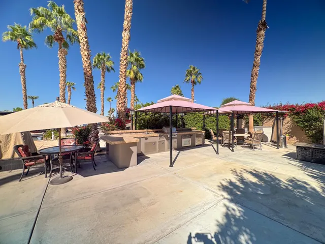 a patio with a table and chairs under an umbrella