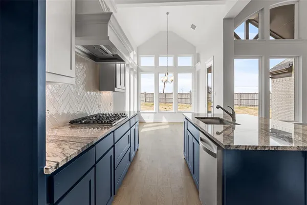 a kitchen with granite countertop a sink stove and cabinets