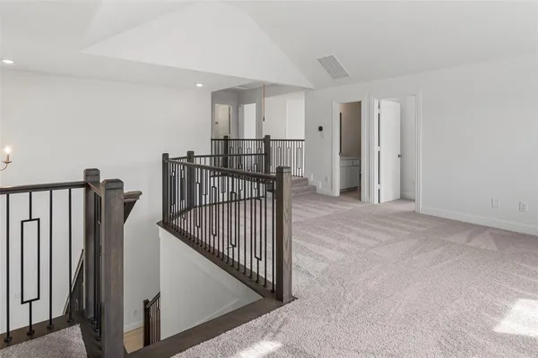 a view of staircase with railing and white walls