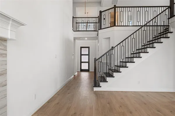 a view of staircase with wooden floor and white walls