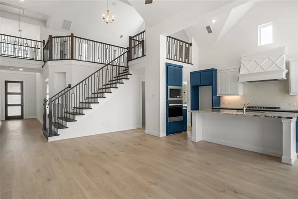 a view of staircase and kitchen with wooden floor