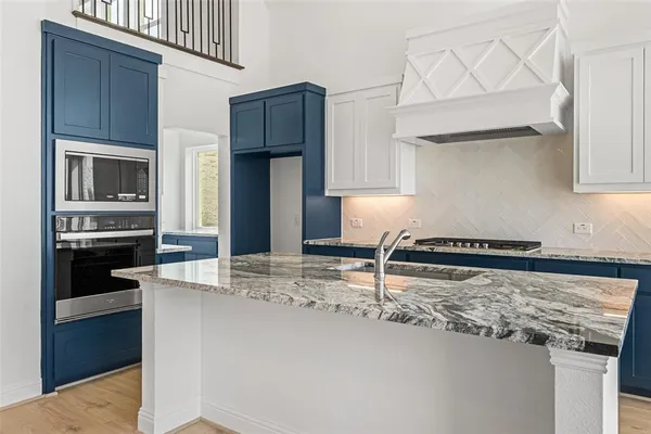 a kitchen with kitchen island granite countertop a stove cabinets and refrigerator