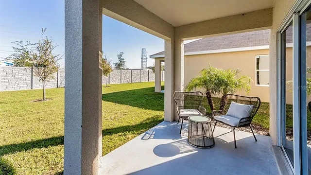 a view of a chairs and table in patio with a yard