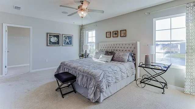 a bedroom with a bed chairs and window