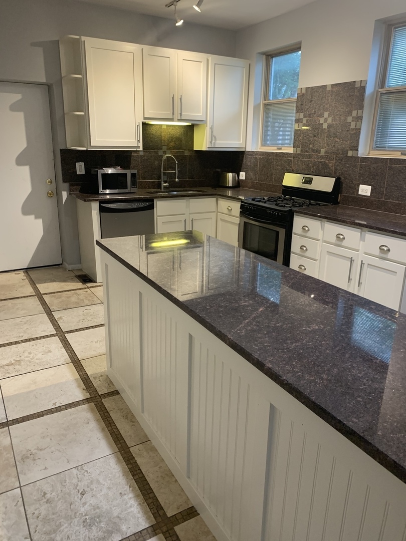 Undisclosed Address Chicago, IL 60657 - Photo 2 of 11 a kitchen with stainless steel appliances granite countertop a sink a stove counter space and cabinets