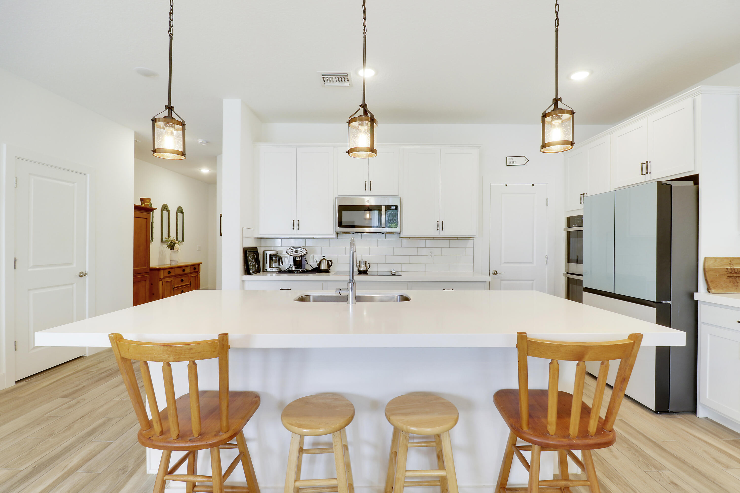 1416 Gopher Terrace Stuart, FL 34994 - Photo 7 of 53 a kitchen with stainless steel appliances granite countertop a stove a refrigerator a kitchen island a dining table and chairs