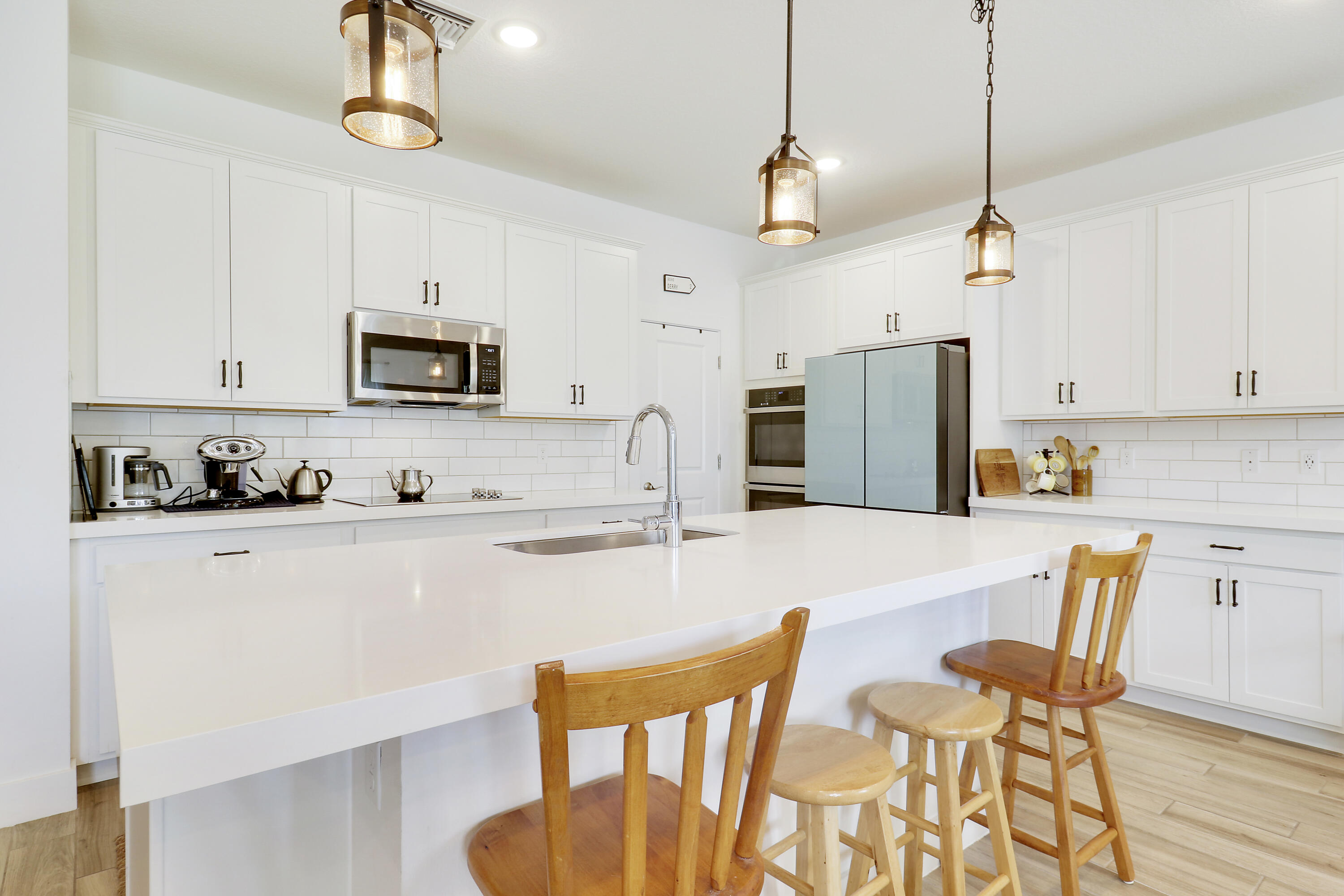 1416 Gopher Terrace Stuart, FL 34994 - Photo 8 of 53 a kitchen with stainless steel appliances granite countertop a dining table chairs refrigerator and microwave