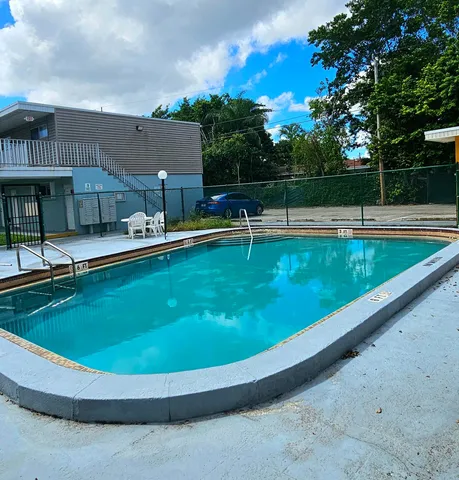 a view of a swimming pool with a garden and trees