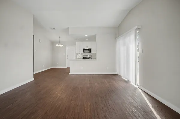 a view of a kitchen with wooden floor and a window