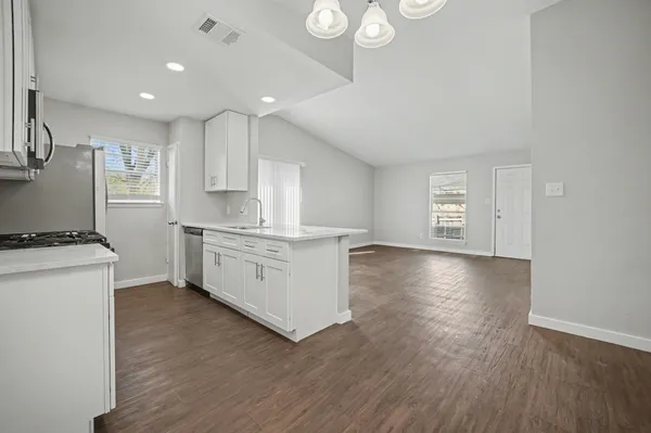 a kitchen with a white cabinets stove and wooden floor
