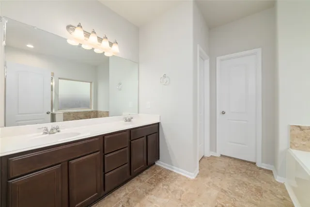 a bathroom with a double vanity sink and a mirror
