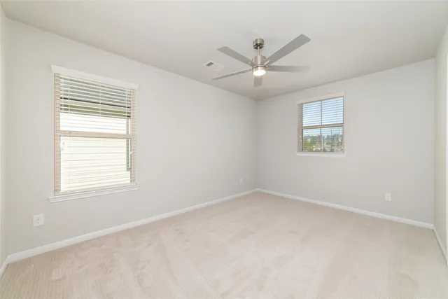 an empty room with a window and a fan