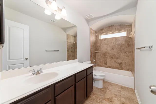 a bathroom with a sink a toilet and a large mirror