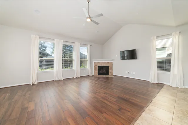 a view of empty room with wooden floor and fireplace