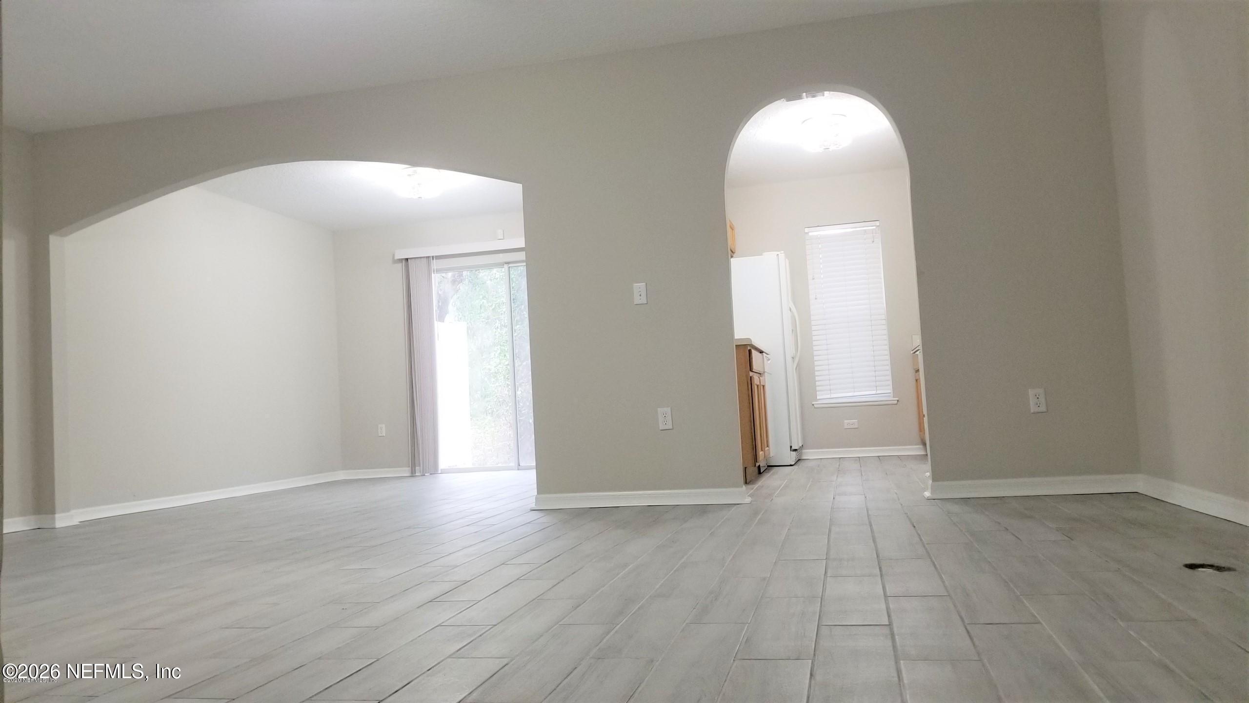 10462 Autumn Trace Road Jacksonville, FL 32257 - Photo 2 of 7 an empty room with wooden floor and mirror