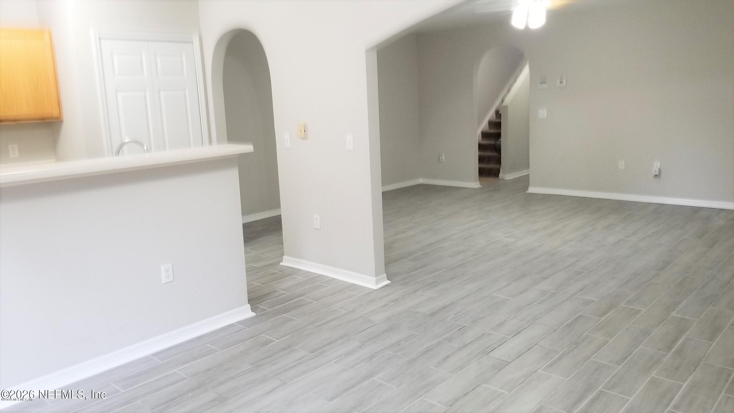 10462 Autumn Trace Road Jacksonville, FL 32257 - Photo 5 of 7 an empty room with wooden floor and windows
