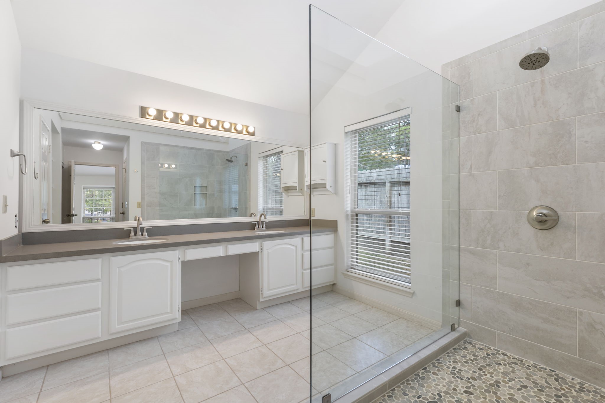 59 Fire Flicker Place Spring, TX 77381 - Photo 20 of 37 Experience luxury with a spacious walk-in shower featuring a sleek glass partition, pebble-tile flooring, and abundant natural light.