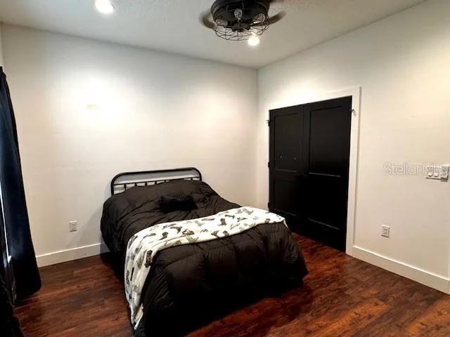 a bedroom with a bed and wooden floor