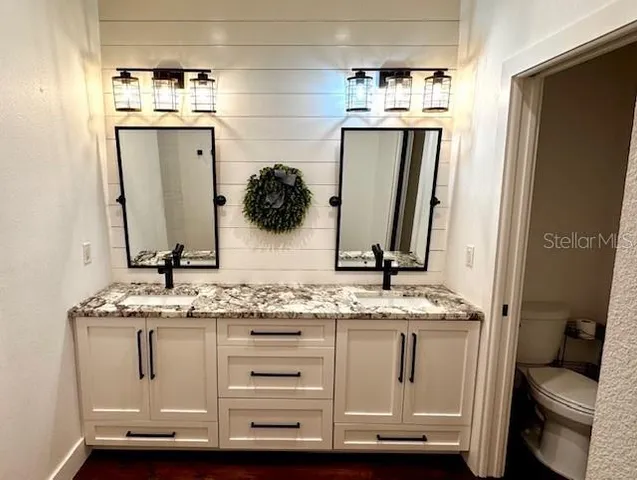 a bathroom with a granite countertop sink and a mirror