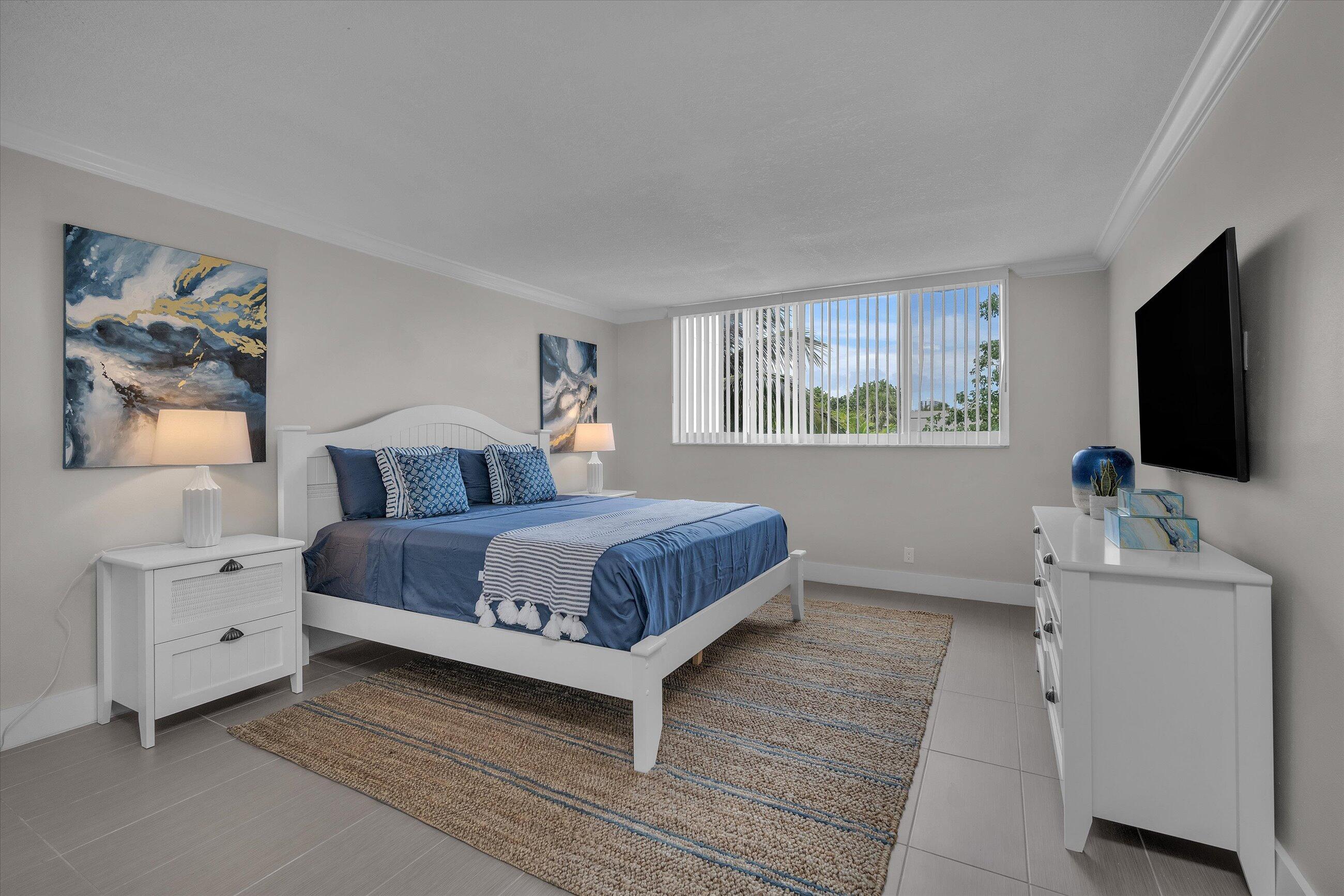 601 North Ocean Boulevard, Unit 203 Boca Raton, FL 33432 - Photo 15 of 20 a bedroom with a bed and a flat screen tv