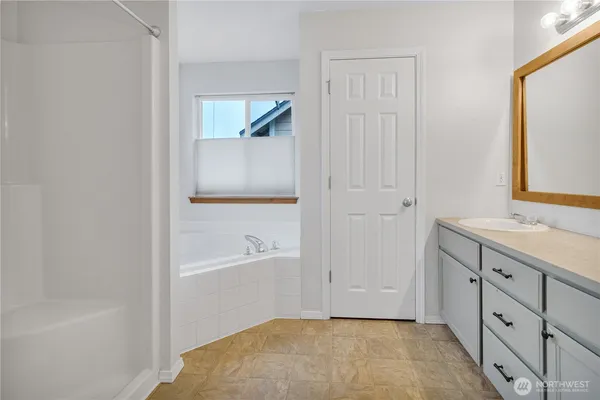 a bathroom with a tub sink and a mirror