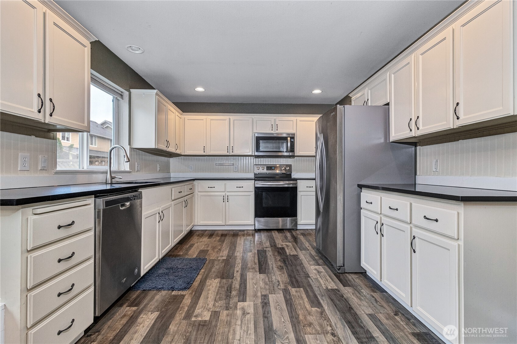 7027 Bailey Street Southeast Lacey, WA 98513 - Photo 10 of 27 a kitchen with cabinets stainless steel appliances a sink and a window