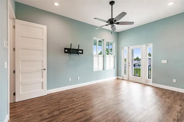 a view of a room with wooden floor and a ceiling fan