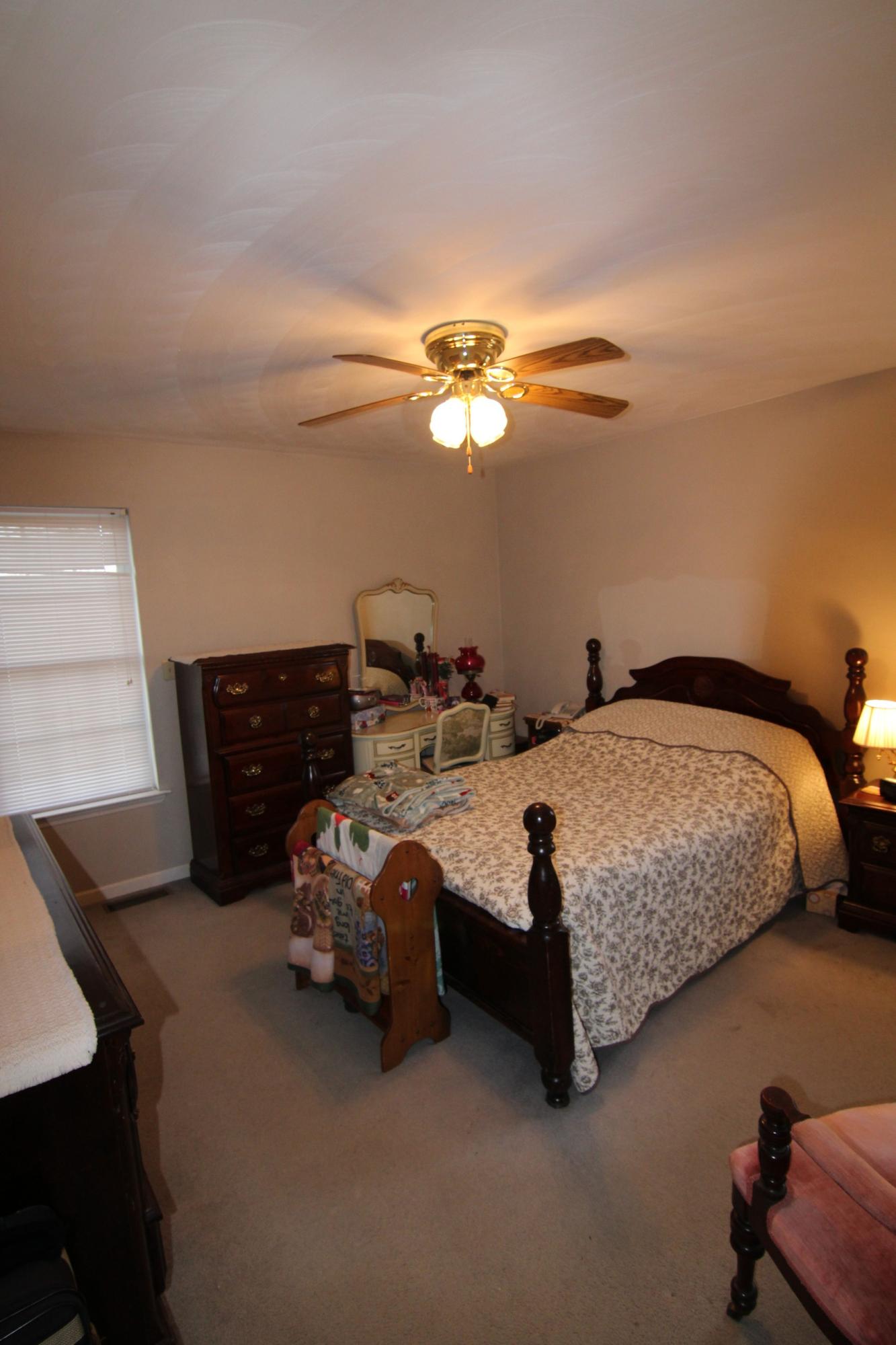 6878 Goodview Road Goodview, VA 24095 - Photo 7 of 15 a bedroom with bed and a chandelier