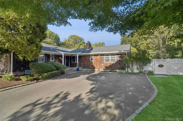 a front view of a house with a yard and potted plants