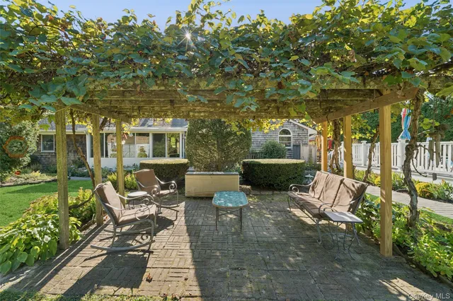 a view of a chair and tables in the patio next to a yard