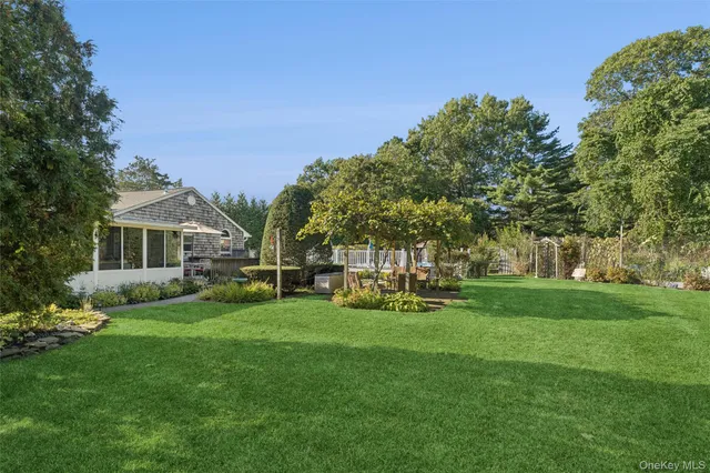 a view of a house with a big yard and sitting area