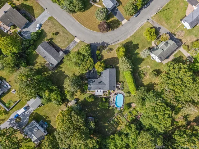 an aerial view of residential house with outdoor space and trees all around