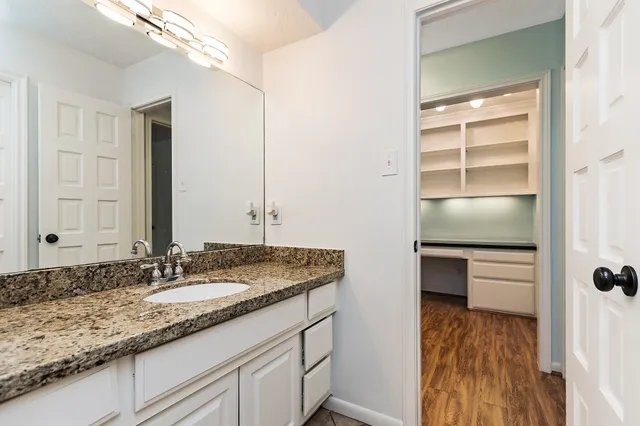 a bathroom with a granite countertop sink and a mirror
