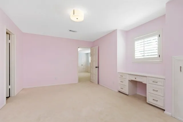 an empty room with windows and cabinet