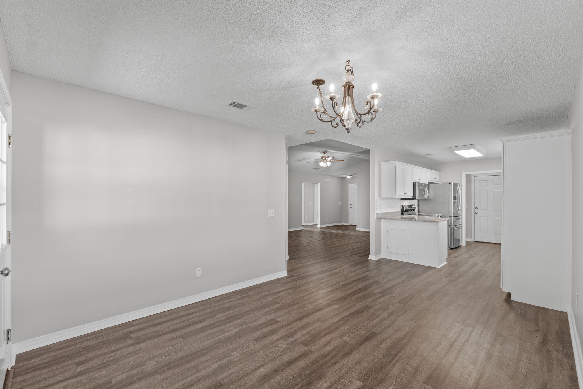 8134 Menorca Street Navarre, FL 32566 - Photo 11 of 54 a view of a room with wooden floor and a kitchen
