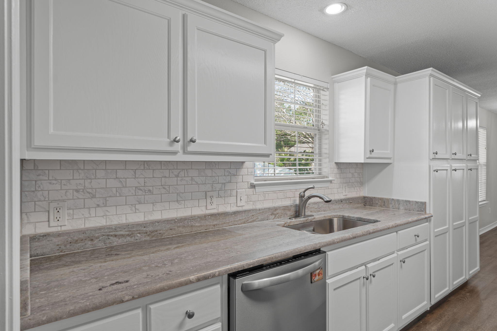 8134 Menorca Street Navarre, FL 32566 - Photo 15 of 54 a kitchen with white cabinets and sink
