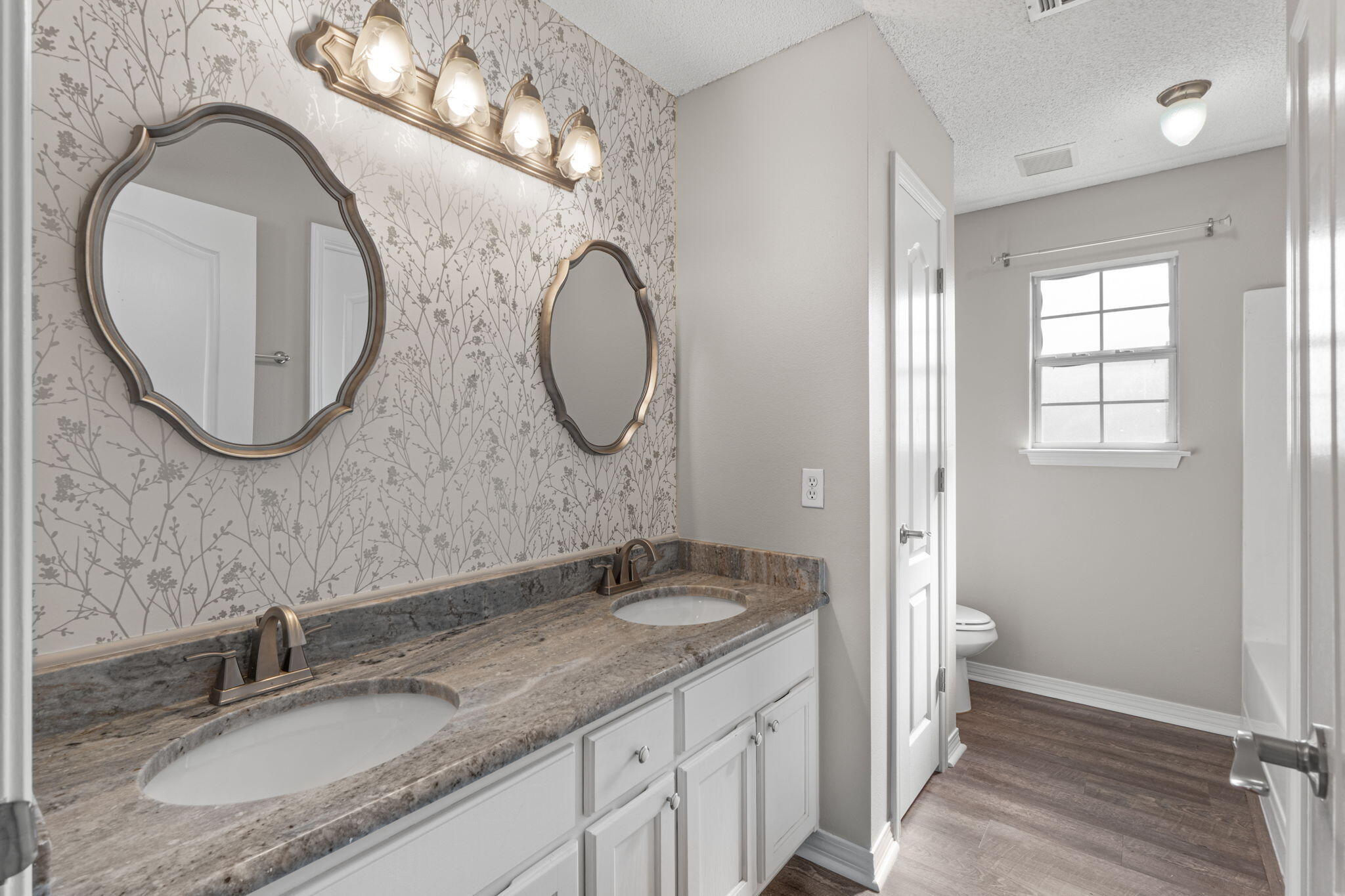 8134 Menorca Street Navarre, FL 32566 - Photo 20 of 54 a bathroom with a granite countertop double vanity sink and a mirror