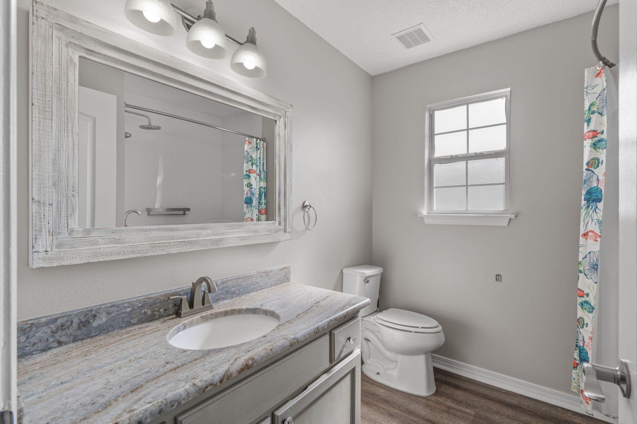 8134 Menorca Street Navarre, FL 32566 - Photo 26 of 54 a bathroom with a granite countertop toilet a sink and a mirror