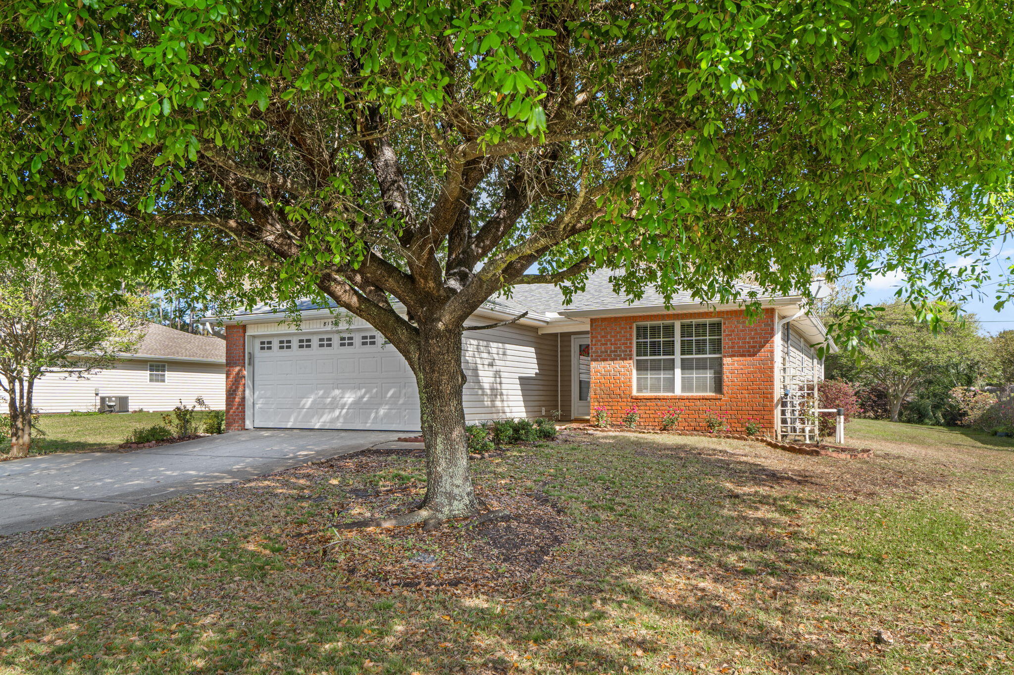 8134 Menorca Street Navarre, FL 32566 - Photo 4 of 54 a house that has a tree in front of it