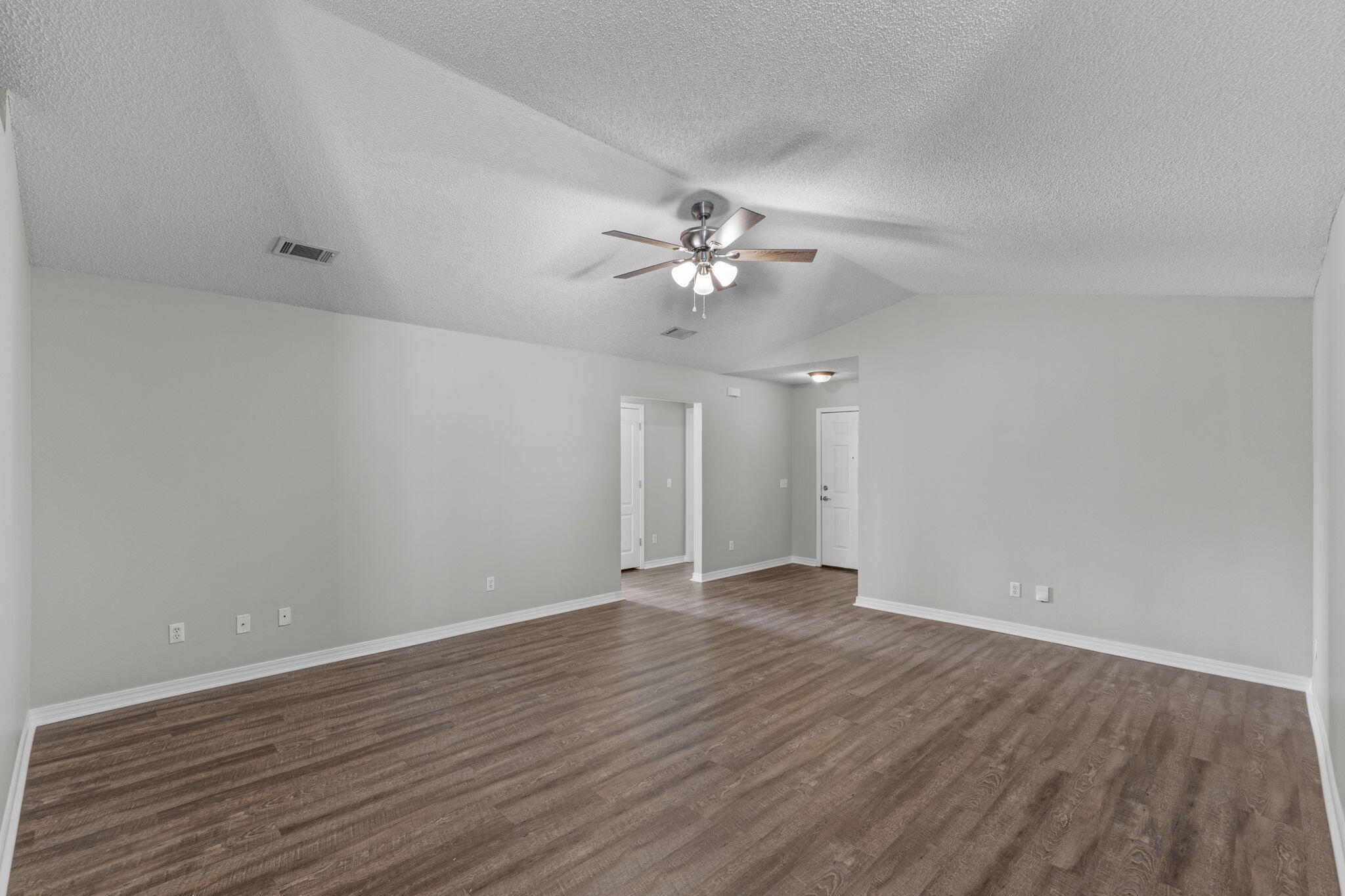 8134 Menorca Street Navarre, FL 32566 - Photo 8 of 54 a view of an empty room with chandelier fan and wooden floor