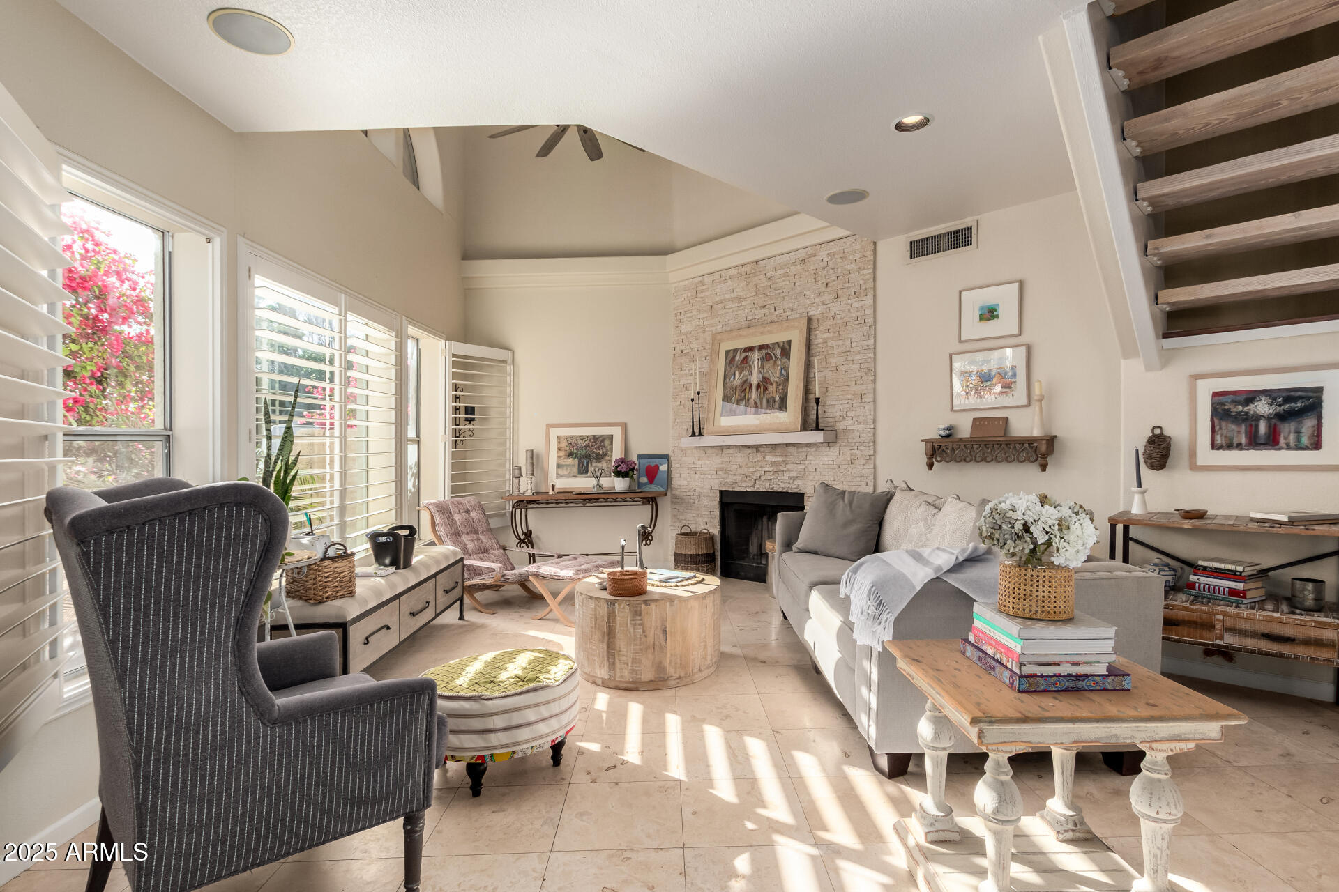 a living room with furniture a fireplace and a floor to ceiling window